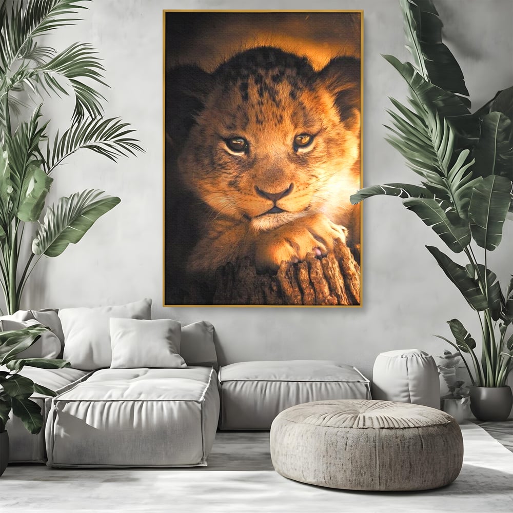 Tablou canvas cu tablou canvas cu portret de pui de leu, in rama de aluminiu auriu, pe perete intr-un living
